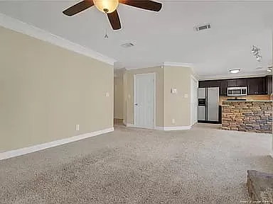 View of living room connecting to entryway and hallway leading to bedrooms and guest bathroom.