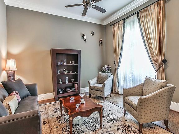 Formal living room with double crown molding and windows overlooking front yard.
