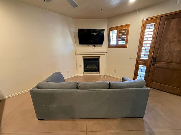 TV mounted over fireplace with sofa.