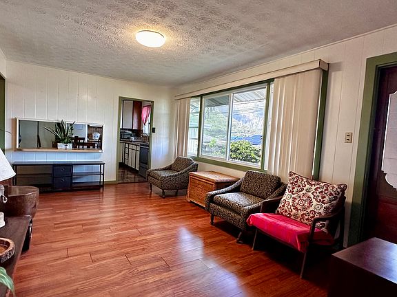 Living room to the kitchen overlooking the Koolau Mountains