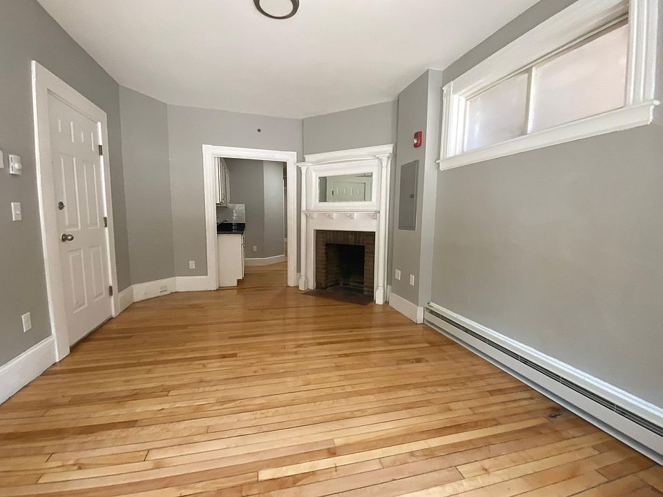 Large and spacious living room with stunning hardwood floors, fireplace (non working but still gorgeous) and beautiful fresh paint.