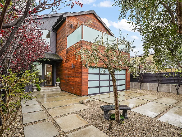 A tall concrete and wood fence surrounds the property and it's driveway
