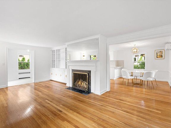 The expansive living room with a fireplace opens to the dining area.
