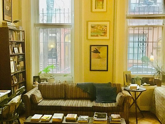 Sunny living room with high ceilings and parquet wood floors