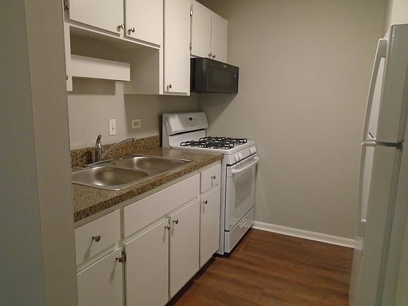 Kitchen, gas stove, microwave, refrigerator.