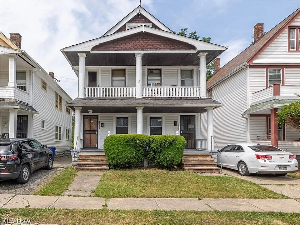 View of front of home featuring a porch, a front lawn, and a balcony