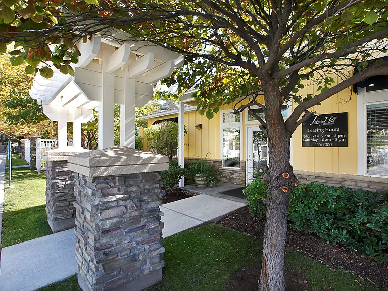 Liberty Hill Apartments, Draper, Utah, entrance with white pergola and stone pillars.