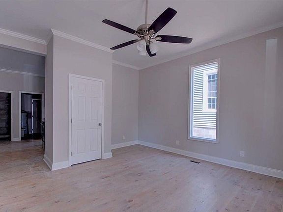 Front door opens to large den with original charm of antique fireplace and large windows overlooking the wonderful sitting porch.