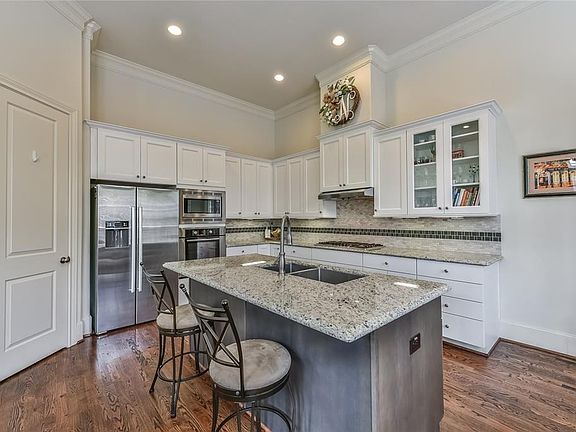 Island kitchen with granite countertops, stainless steel appliances, and breakfast bar.