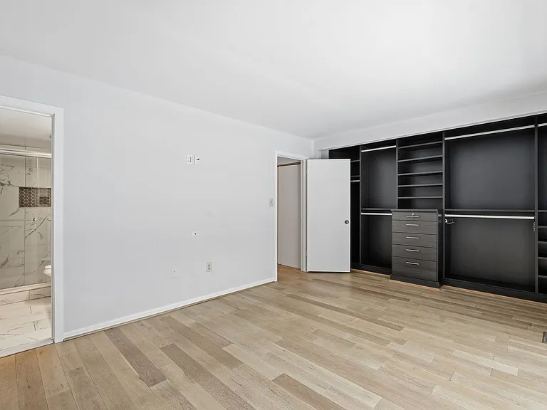 primary bedroom closet and view of primary bathroom