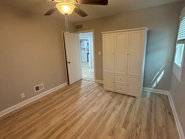 Master bedroom with closet behind door and wardrobe closet
