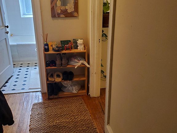 Entrance with hallway coat closet; bedroom to left, living room and kitchen to the right