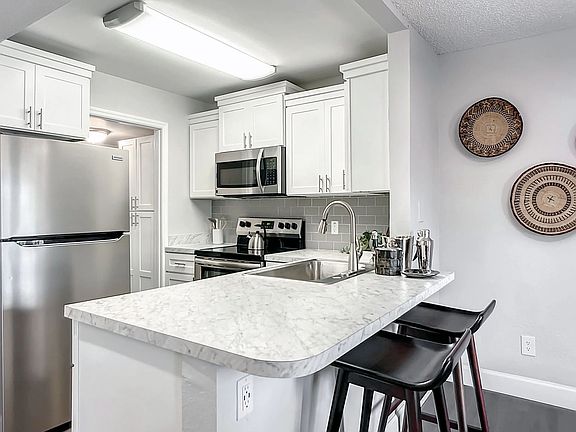Elevate your cooking experience in our renovated gourmet kitchens with stunning white marble-inspired countertops and a breakfast bar.