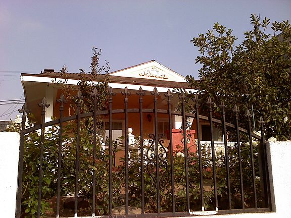 Fenced front yard with fruit trees lined with white roses