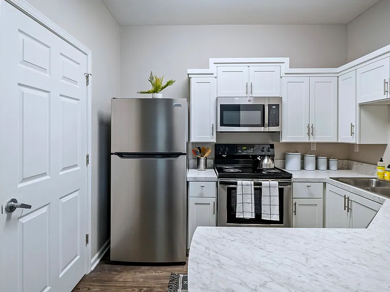 Fall in love with the newly remodeled kitchen, where stunning white marble-inspired countertops create a magical ambiance for your culinary adventures and a breakfast bar that opens to the living space for full enjoyment.