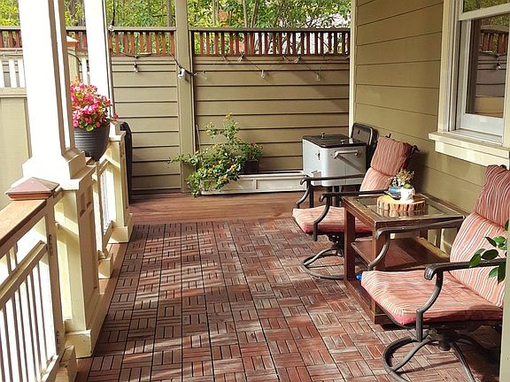 Porch seating and entertaining area with outdoor overhead fan, beadboard ceiling and arbor