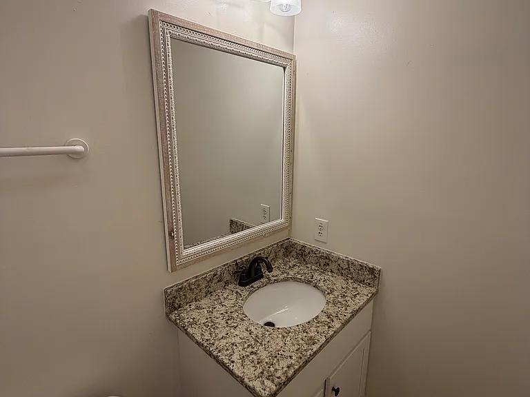 Half bath with new granite countertop, new vanity, lovely mirror, and new lights