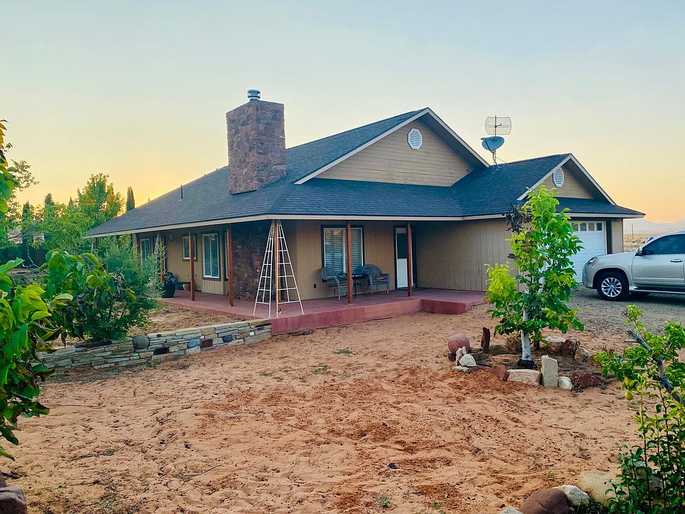 Beautiful home with wrap around patio, brick wall for privacy, mature trees and artistic stone retaining walls.
