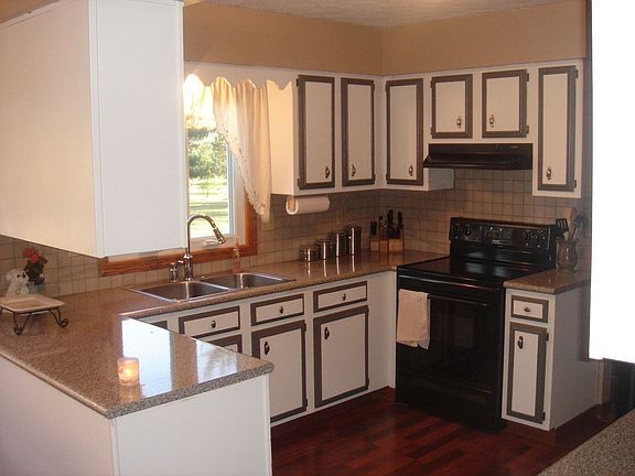 Efficiently designed kitchen is enhanced by new laminate floors & countertops.