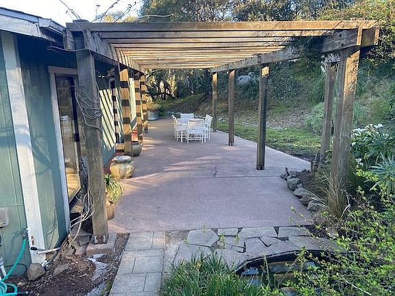 Arbor covered patio with Jasmine and Wisteria, plus waterfall and pond with little fishes