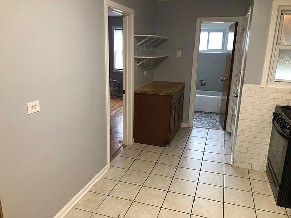 Room for a breakfast table with convieniant outlet. Food grade cutting board counter top with additional storage and shelving.