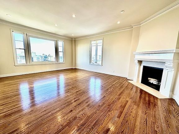 Unit #504 MASSIVE living room with wood-burning fireplace, hardwood floors and recessed can lighting throughout!