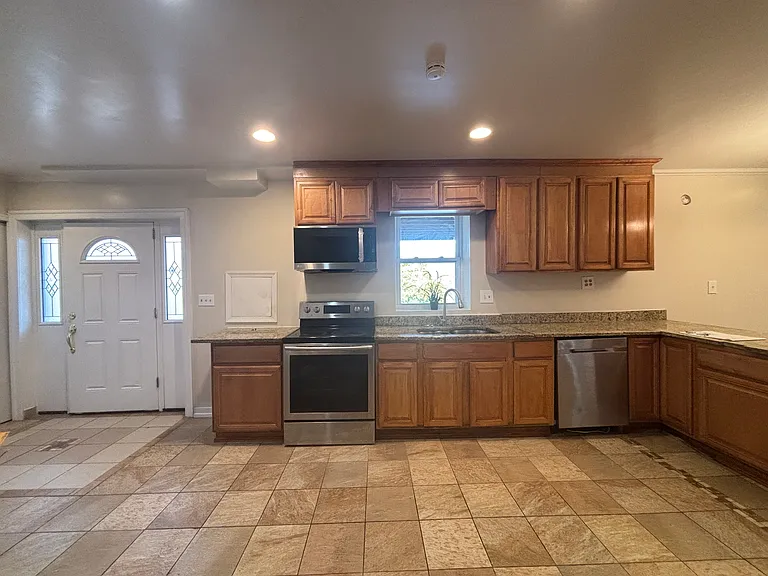 kitchen & foyer: electric range, new microwave, dishwasher, and refrigerator included