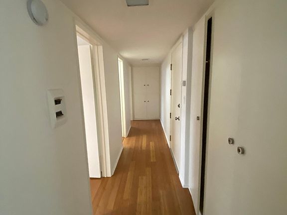 Hallway with linen storage and half bath