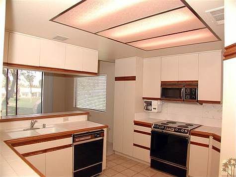 Kitchen with access to dining area and rear patio.
