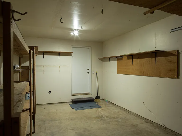 Garage area with additional storage space and direct access to the interior corridor leading to the living room and kitchen.