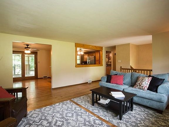 Large living area with freshly buffed hardwood floors and plenty of natural light.