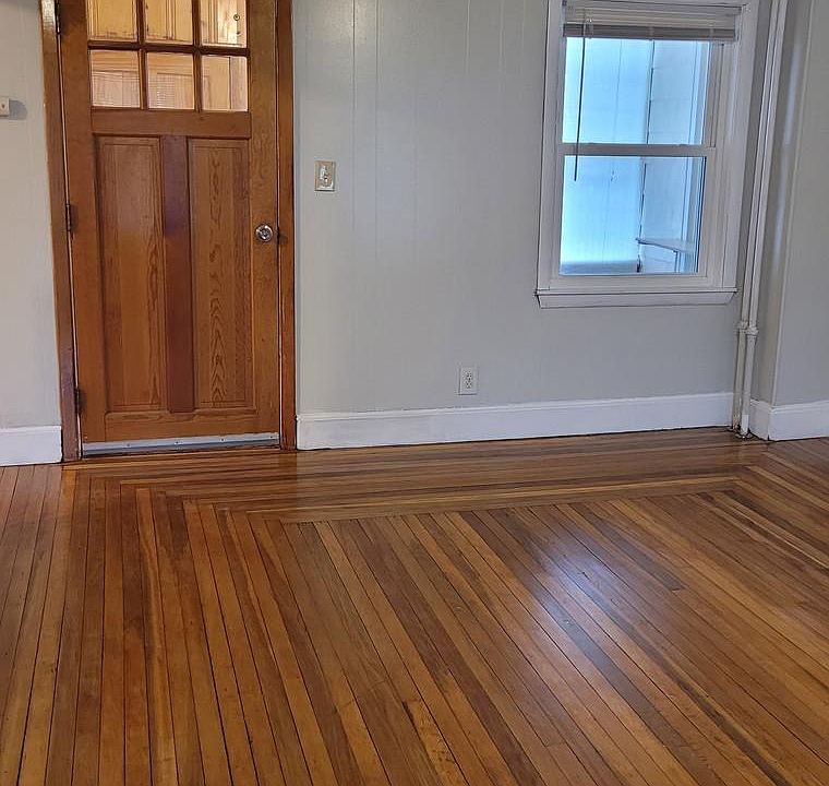 Large and bright open living area with hardwood floors.