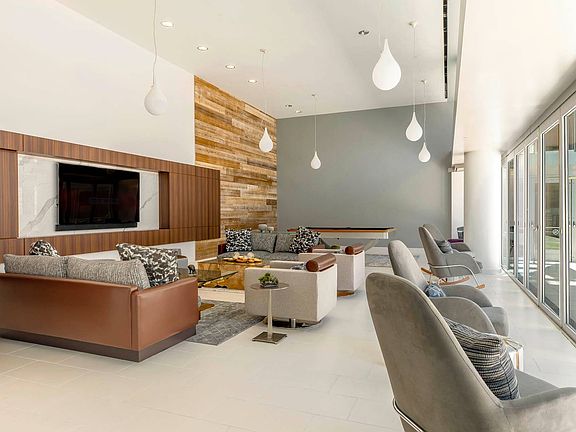 A sophisticated communal lounge featuring plush seating, a flat-screen TV, and recreational amenities, offering a perfect space for relaxation or social gatherings.