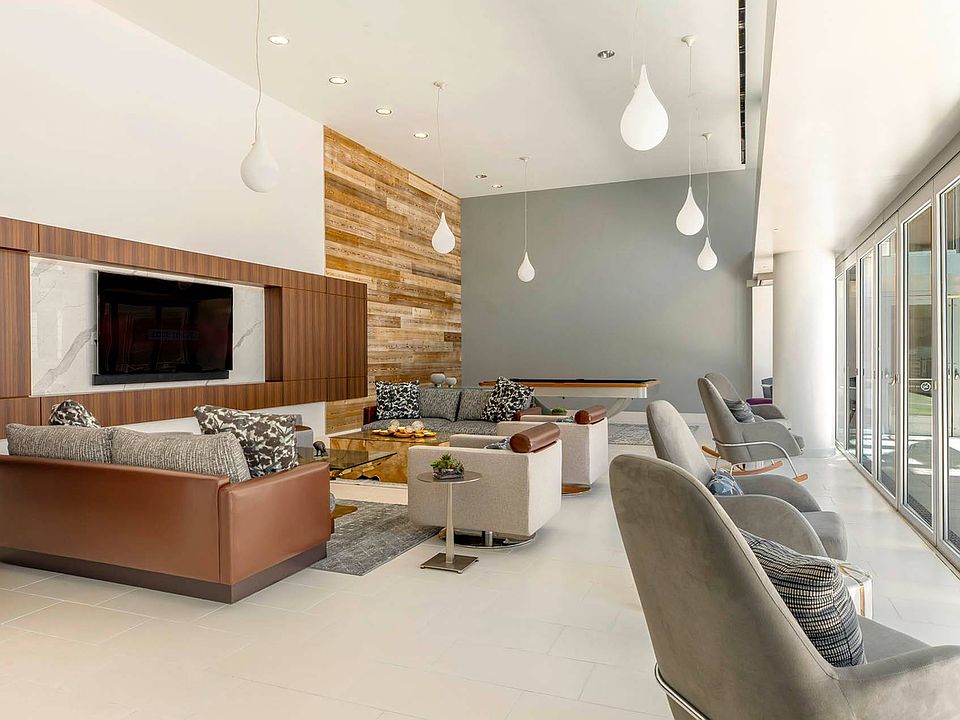 A sophisticated communal lounge featuring plush seating, a flat-screen TV, and recreational amenities, offering a perfect space for relaxation or social gatherings.