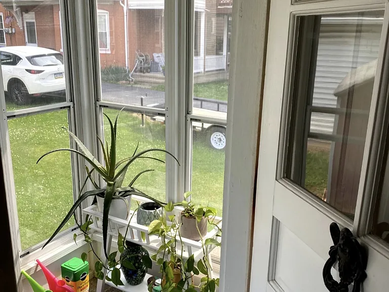 Small side porch with windows and screens is off of the kitchen.