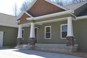 The front of the home has an inviting covered front porch. The pillars are accented with stones. Woo