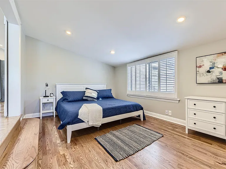 Larger primary bedroom, king bed pictured and large wardrobe across from dresser
