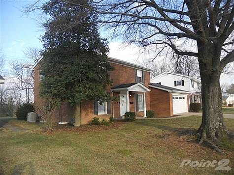 The home is nestled among large trees front and back.