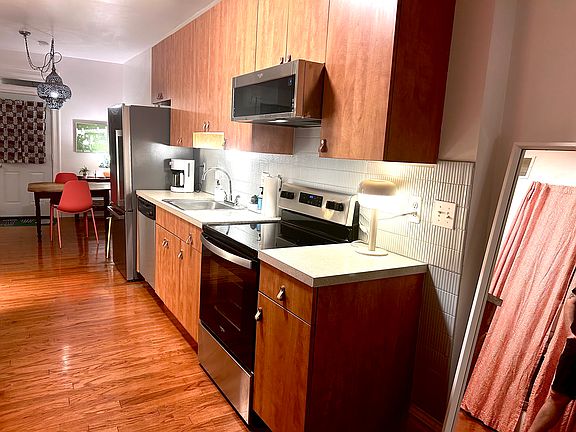 Kitchen with electric range, ceramic backsplash and over-the-counter microwave