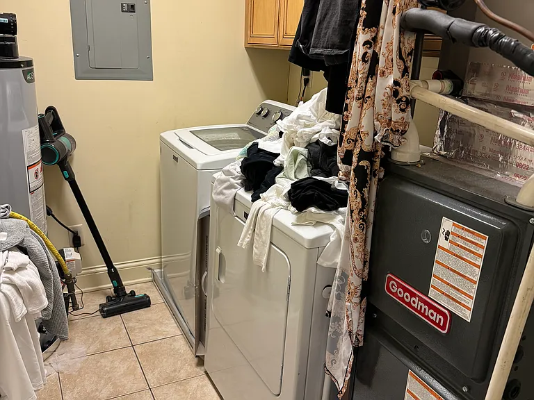 On the opposite side of the den (left of hallway) is full laundry/utility room with additional storage space