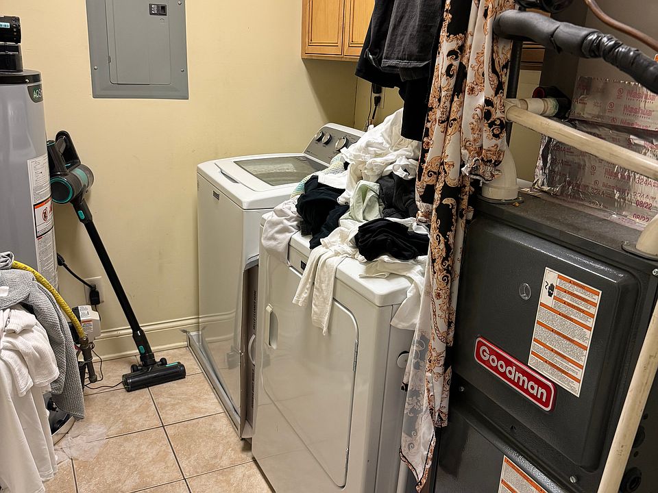 On the opposite side of the den (left of hallway) is full laundry/utility room with additional storage space
