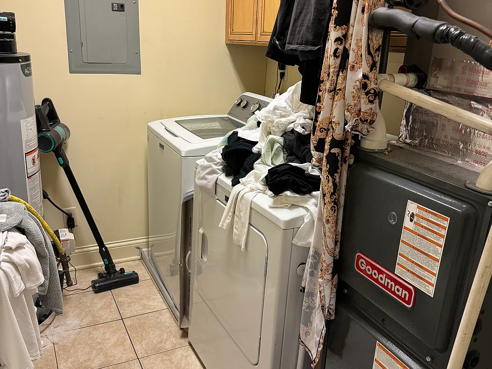 On the opposite side of the den (left of hallway) is full laundry/utility room with additional storage space