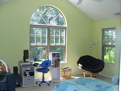 Guest suite has walk-in closet, adjacent bathroom, view of green space.