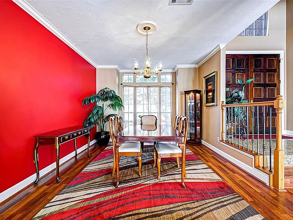 Another view of the formal dining room with gleaming wood flooring and ornate spindles and balusters, making this the perfect place for private dinner parties and festive entertaining.