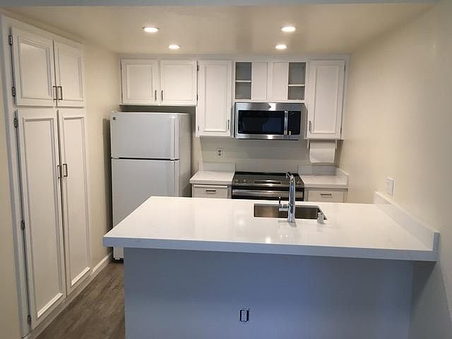 Remodeled kitchen with marble countertops, new range and microwave, new flooring, deep stainless steel sink, and lots of storage. Dishwasher and garbage disposal, too!