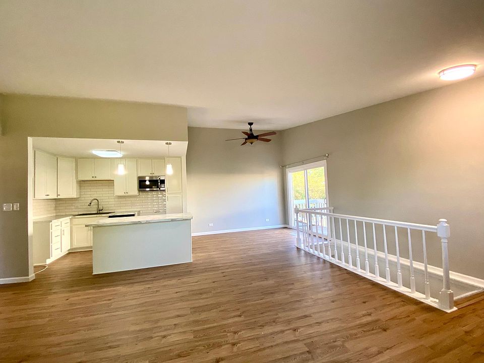 Open living space with living room, kitchen, and dining room with access to the balcony from the sliding glass door.