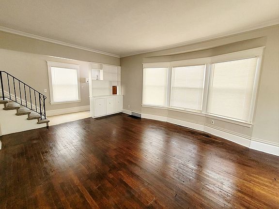 Living room with access to entry, upper level staircase and storage built in