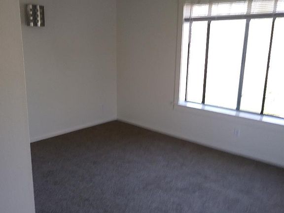 Part of the living room. There's another window on the right side as this is a corner unit. Carpet is new.