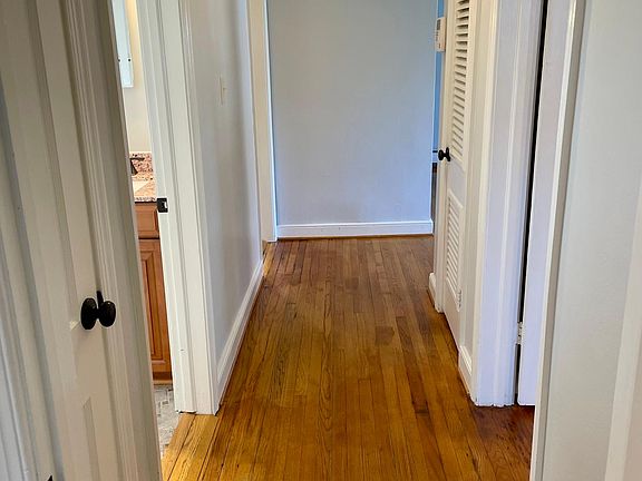 Main hallway looking back to the family room. Linen closet, full bathroom and kitchen on the left. Master bedroom and pantry on right.