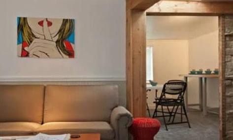 Sitting and dining area with exposed beams and brick